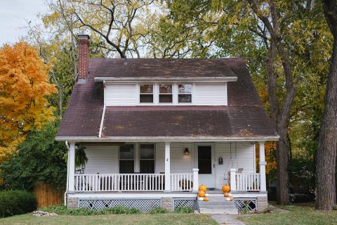 a photo of a two story house with autumnal decorations